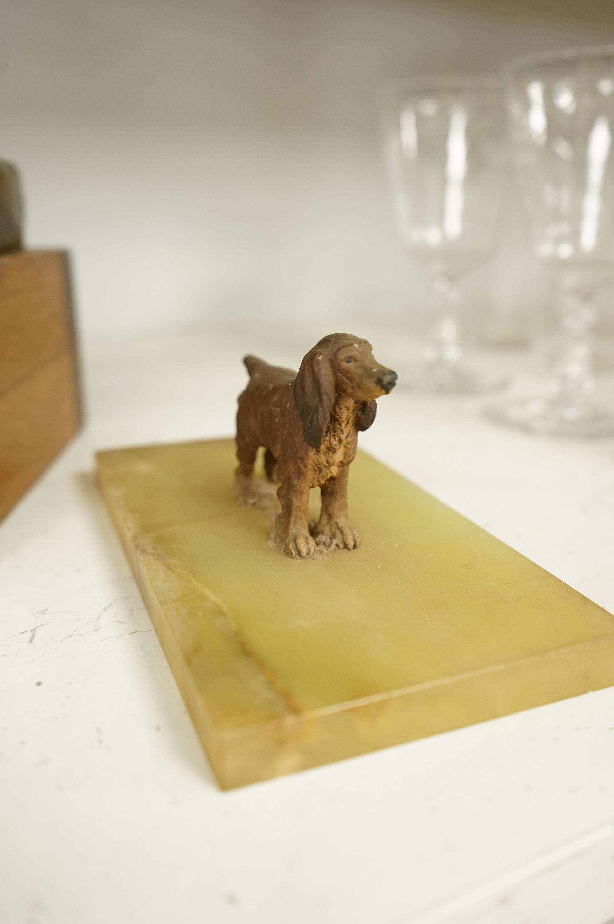 An abstract bronze model of a cow, 34cm and an Art Deco green onyx box, the lid surmounted with a cold painted bronze spaniel, 16.5cm wide.
